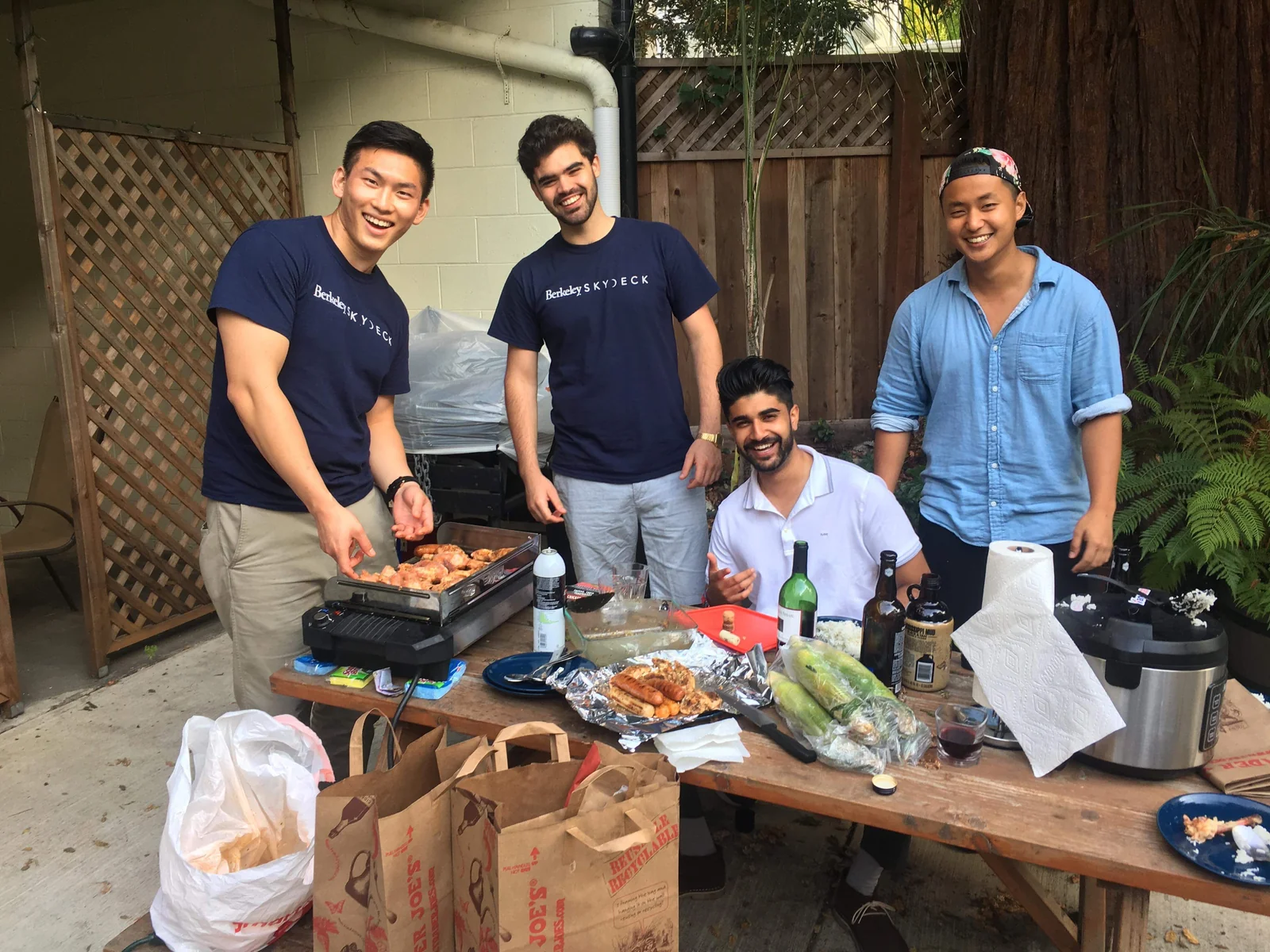 A group gathered around a barbecue outdoors.