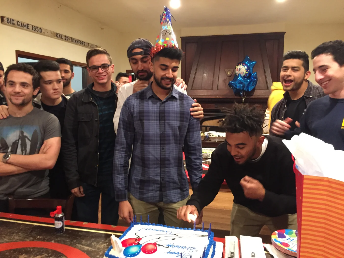 A group gathered around a cake.