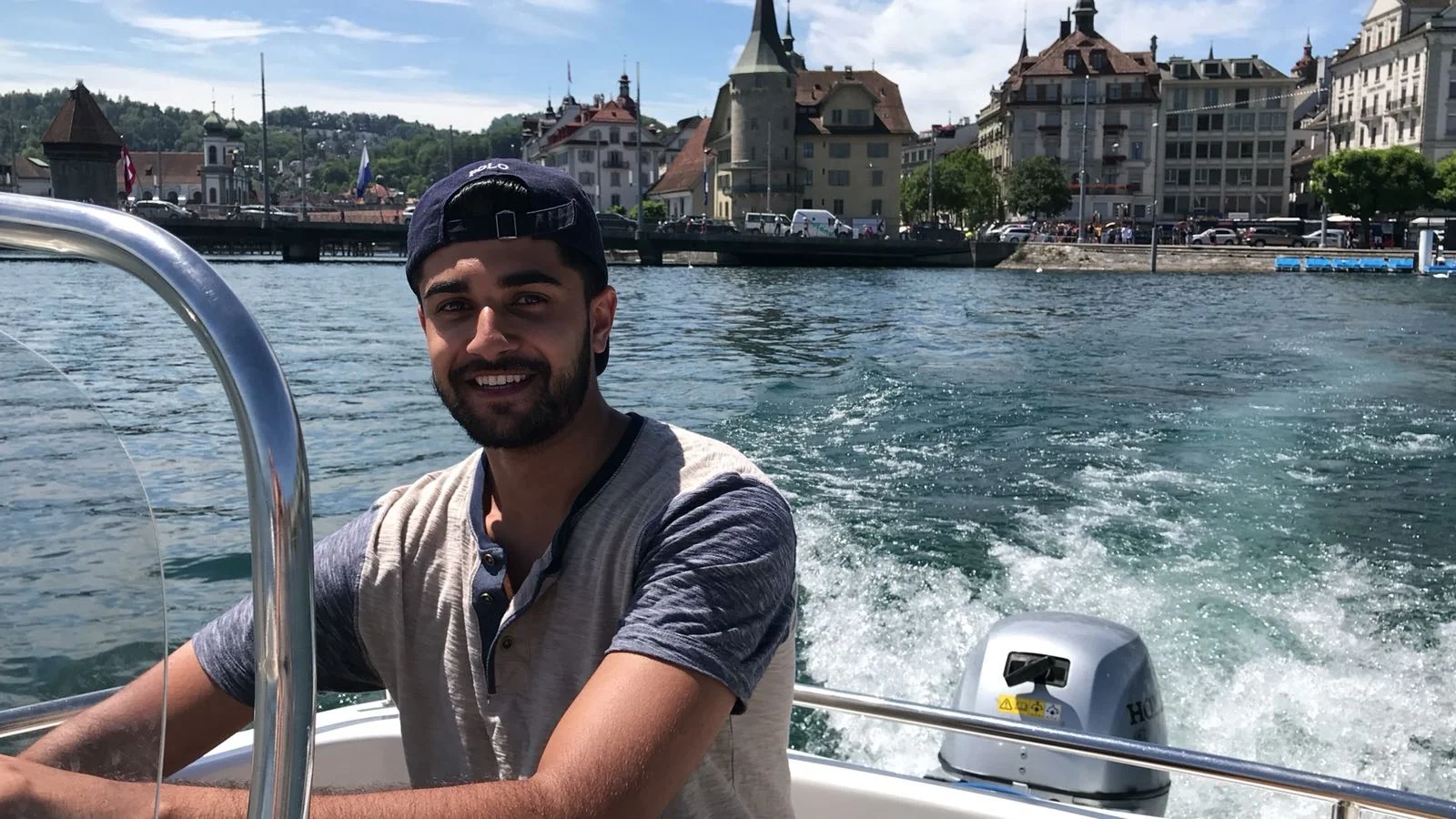 Steering a motorboat with a waterfront and the boat's wake behind me.