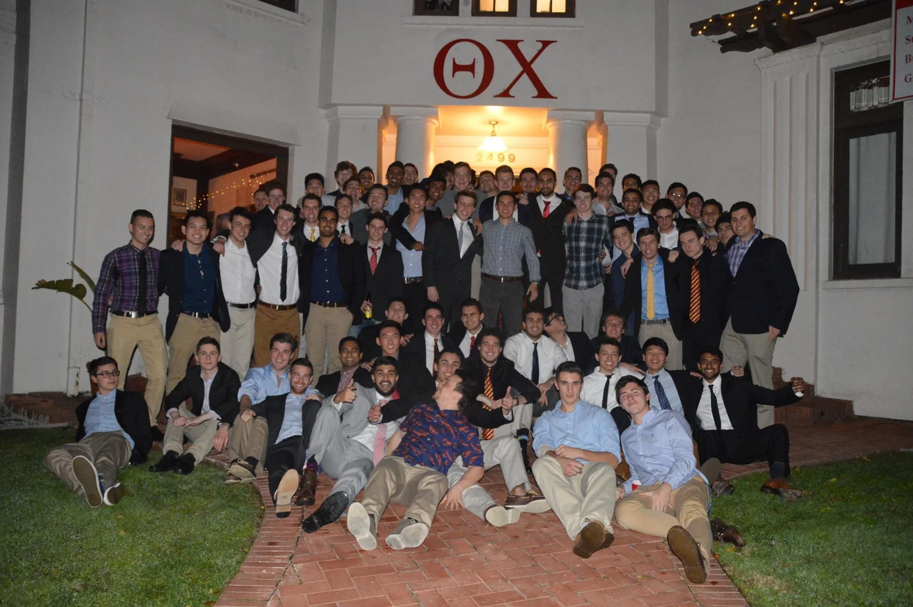 A Theta Chi group photograph outside the fraternity house.