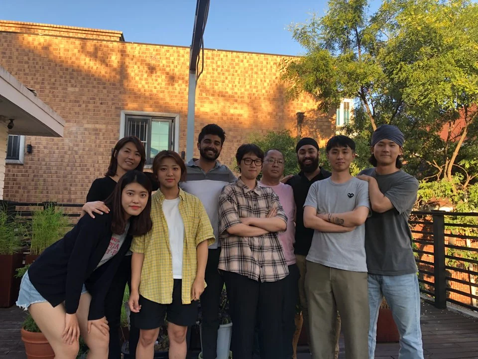 Part of our group in Korea, gathered outside by a brick building.