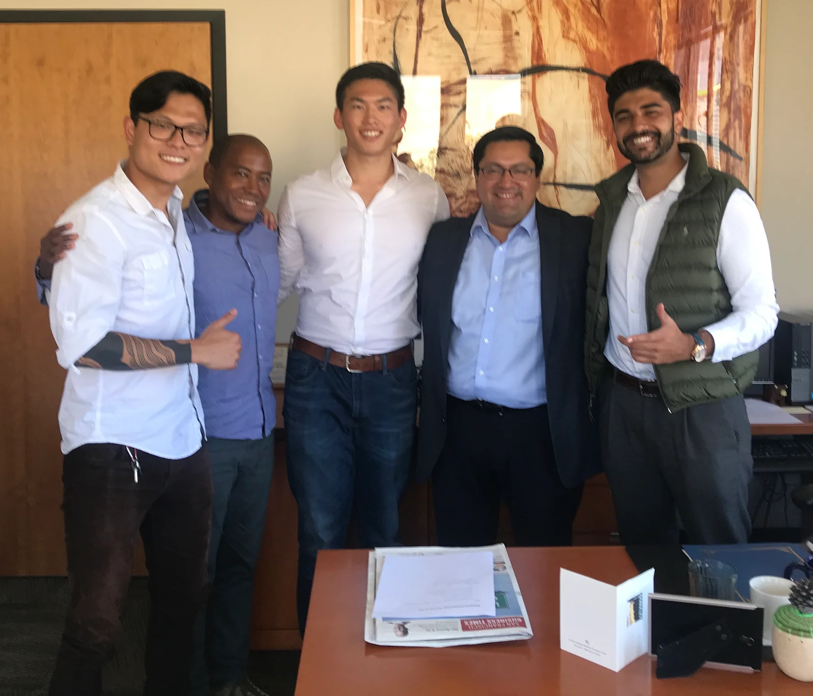 Five people standing together in an office.