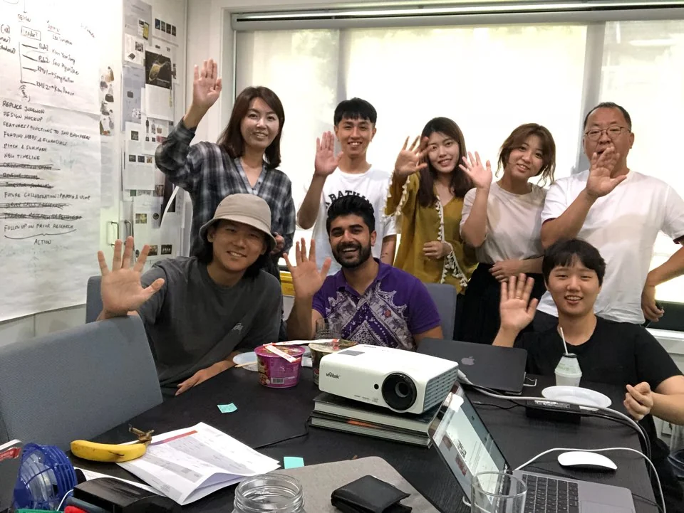 A workshop group waving around a table of laptops and handwritten notes.